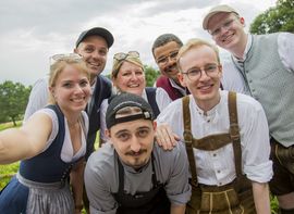 Selfie von jungen Platzl-Mitarbeitern, alle in traditioneller Tracht, eine Mischung aus Männern und Frauen